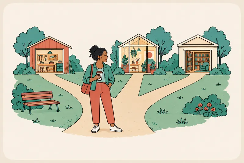 A person with a coffee stands where three park paths meet, looking toward one of three small buildings: a workshop, a studio and a library.